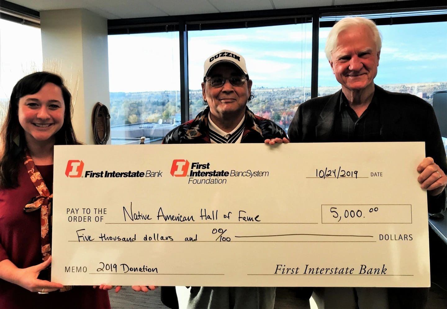 A group of people holding up large checks.