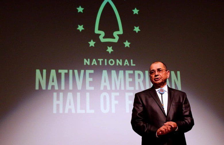 A man in suit and tie standing on stage.
