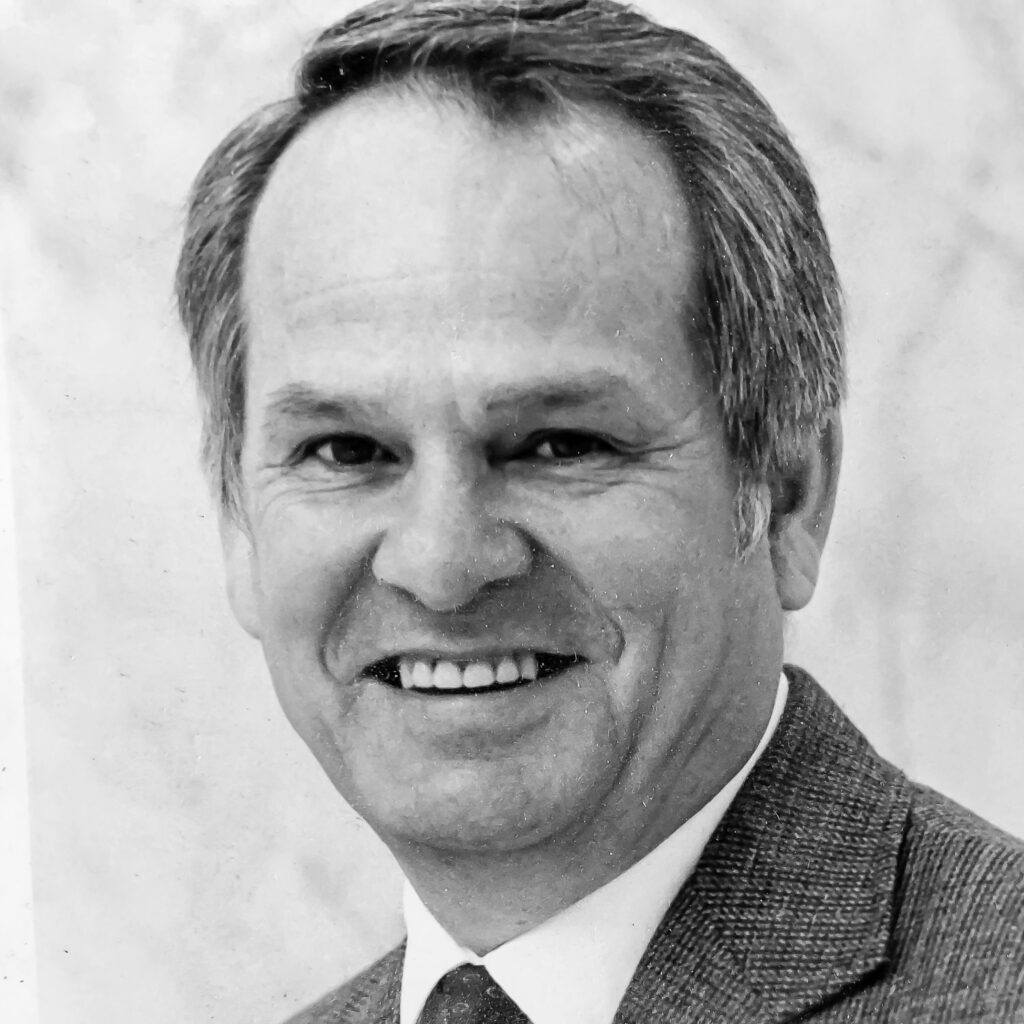 A man in suit and tie smiling for the camera.