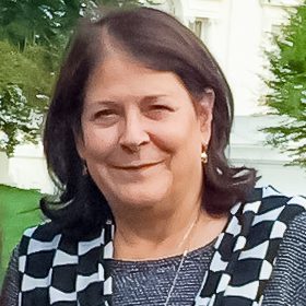 A woman with long hair and a checkered scarf.