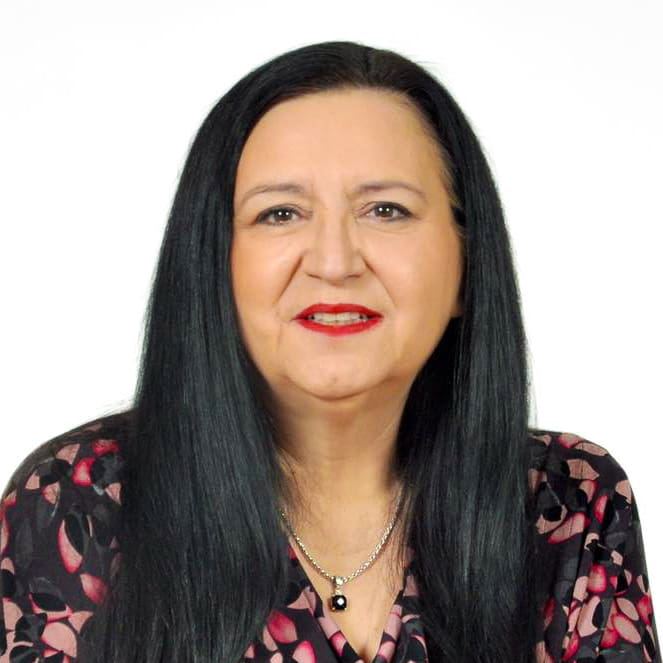 Woman with long black hair, floral blouse.