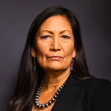 Person with long hair and beaded necklace.