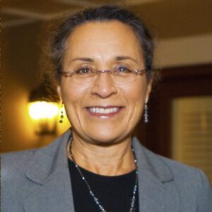 Smiling mature woman with glasses and gray blazer
